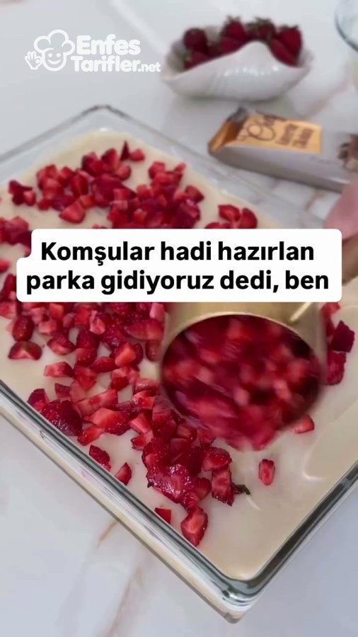 Krema kaplı kekin üzerine doğranmış çileklerin dağıtılması