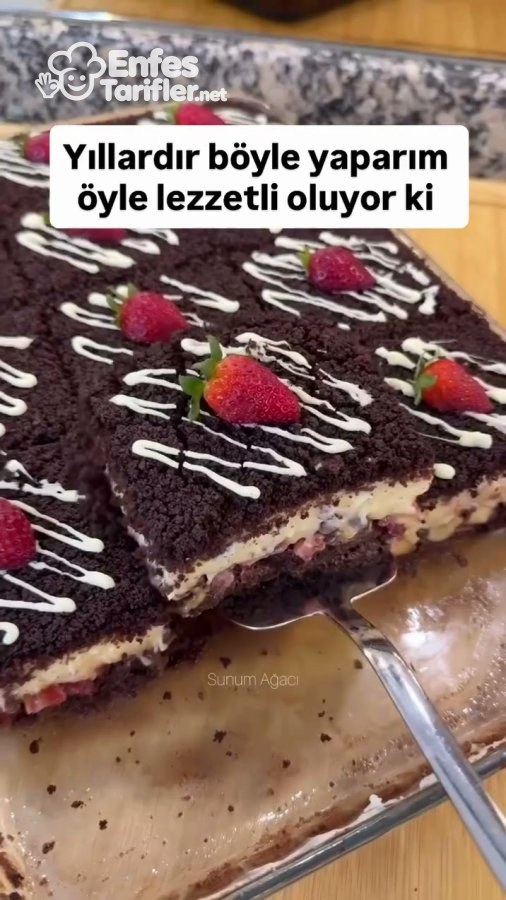 Borcamdan spatulayla alınan, meyveli krema katmanı görünen köstebek pasta dilimi