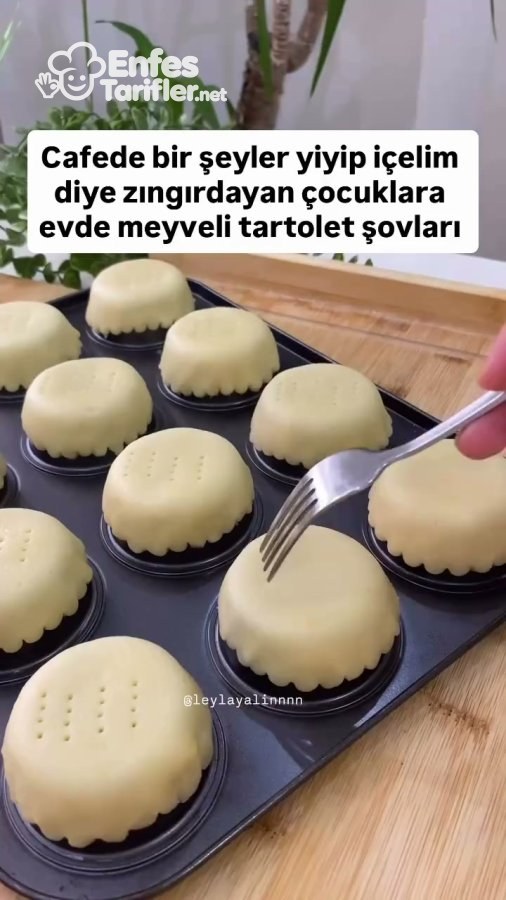 Ters çevrilmiş muffin kalıbına yerleştirilen tart hamurlarının çatalla delinmesi