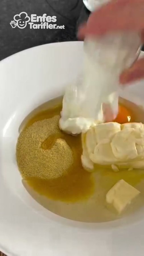 Tereyağı, irmik, sıvı yağ ve yumurtanın bulunduğu kaba yoğurt eklenmesi