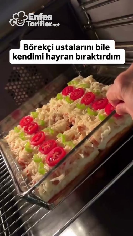 Kaşar, domates ve biberle kaplanan lavaş böreklerinin fırına yerleştirilmesi