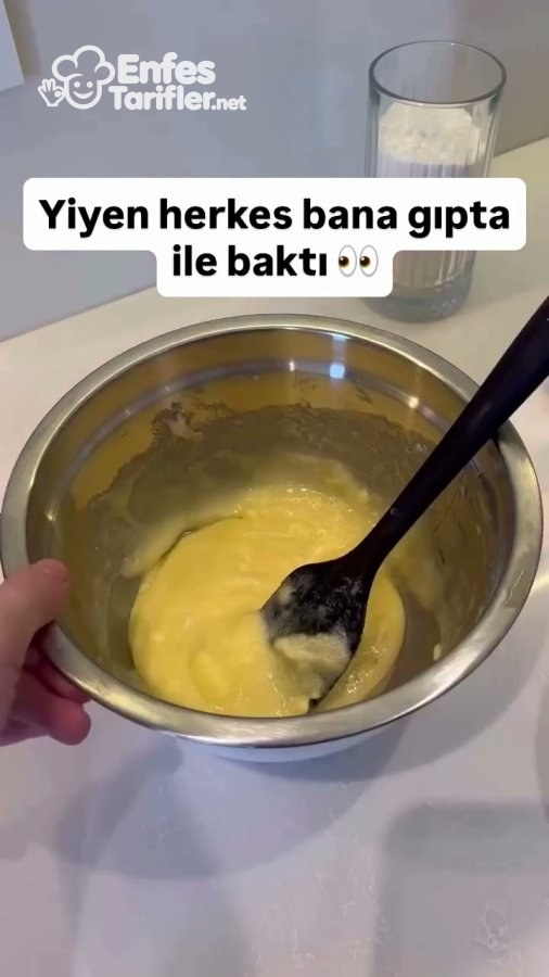 Metal kapta spatulayla karıştırılmış sarı renkli kurabiye harcı