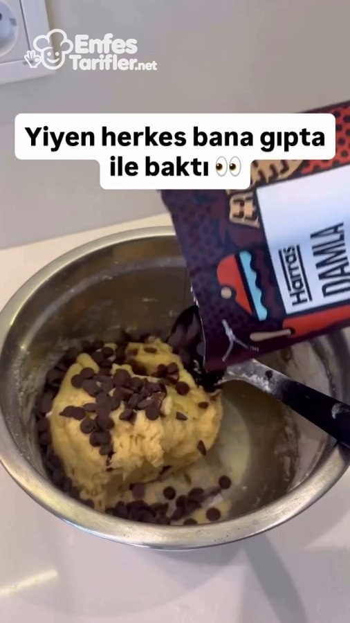Kurabiye hamurunun üzerine paketten damla çikolata dökülmesi