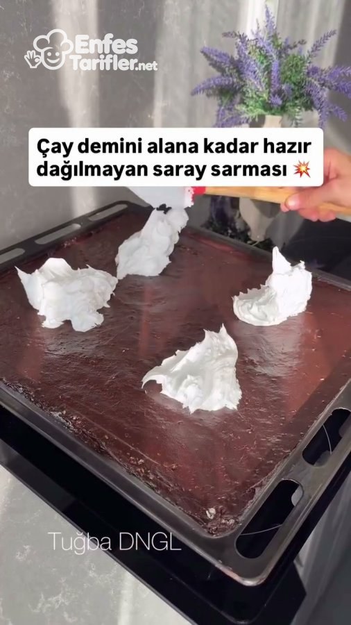 Tepsiye yayılmış kakaolu muhallebinin üzerine krem şanti konulması