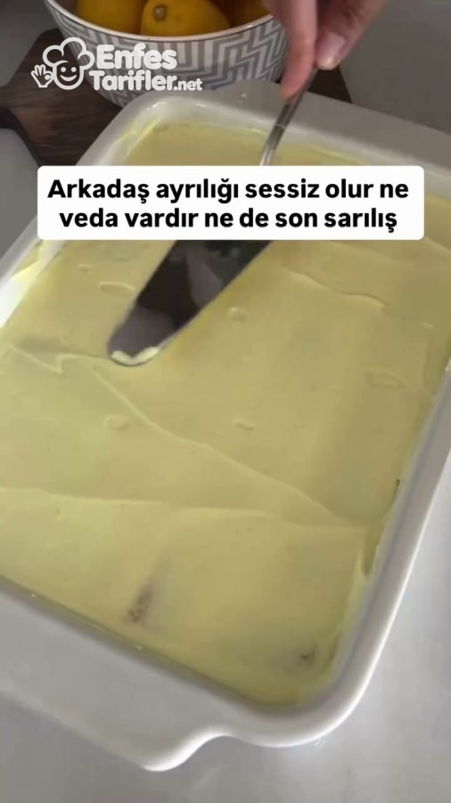 Servis kabındaki tiramisunun krema yüzeyinin spatulayla düzeltilmesi