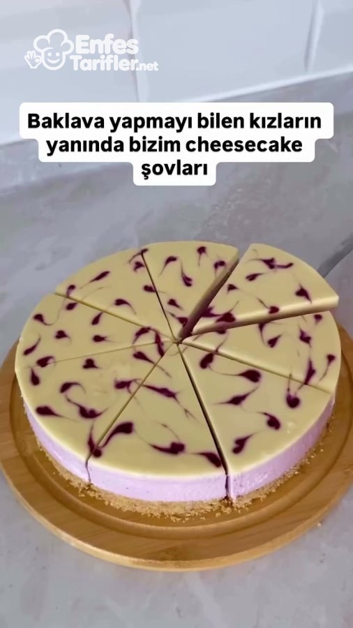 Beyaz çikolata kaplaması meyve sosuyla desenlenmiş cheesecake'in dilimlenmiş hali