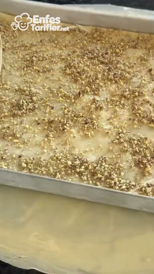 Tepsideki baklava yufkasının üzerine serpilmiş ince çekilmiş kuruyemiş