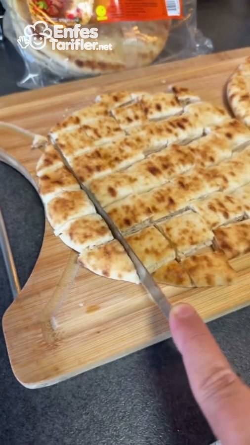 Mangal ekmeğinin kesme tahtasında küçük parçalara doğranması