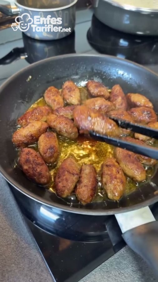 Tavada kızaran küçük köftelerin maşayla çevrilmesi