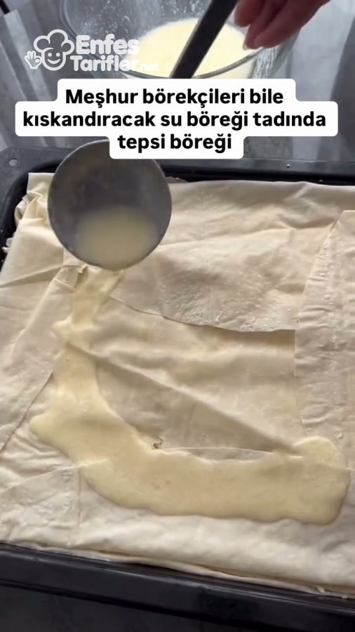 Tepsideki yufka katlarının üzerine börek sosu gezdirilmesi