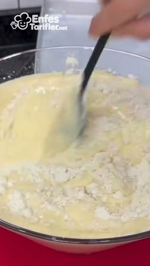 Cam kasedeki kek karışımına eklenen unun spatulayla karıştırılması.