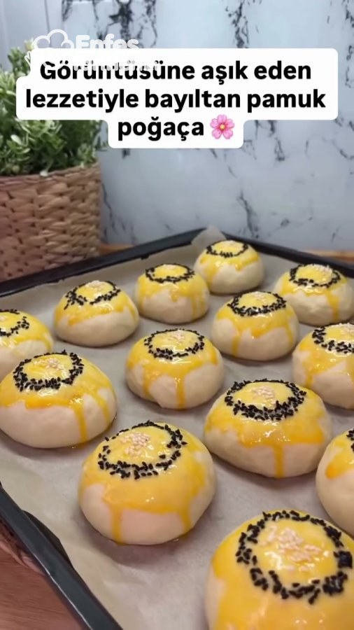 Yumurta sarısı sürülüp çörek otu halkası ve susamla süslenmiş, fırına hazır poğaçalar